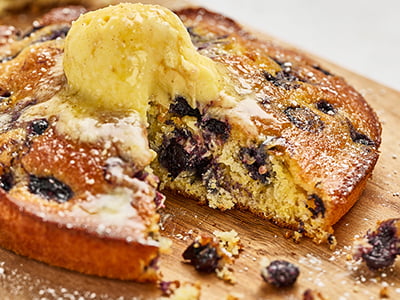 Freshly baked cornbread with sweet summer blueberries. Topped with house-whipped lemon butter and lightly dusted with powdered cinnamon sugar.