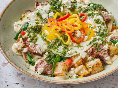 Seared steak, spinach, Cheddar and Monterey Jack, diced red bell peppers and onions in a potato hash topped with two cage-free eggs any style, crumbled Feta cheese, house-pickled sweet peppers, roasted garlic aioli and a drizzle of chimichurri sauce.