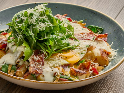 Diced hardwood smoked bacon, house-roasted onions, sautéed spinach and Mozzarella in a potato hash. Topped with two cage-free eggs any style, two strips of hardwood smoked bacon, Parmesan cream sauce, freshly cracked black pepper, lemon-dressed arugula, shaved Parmesan and fresh herbs.