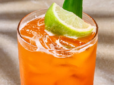 Thai tea, pineapple, lime, organic ginger and cane sugar, garnished with a lime wedge.