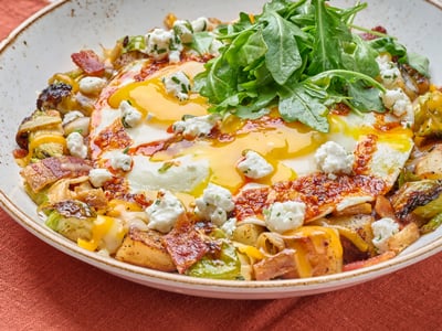 Hardwood smoked bacon and honey-roasted brussels sprouts in a potato hash topped with Cheddar and Monterey Jack, house-roasted onions, two cage-free eggs any style, herbed Goat cheese, lemon-dressed arugula and a drizzle of chili crisp.