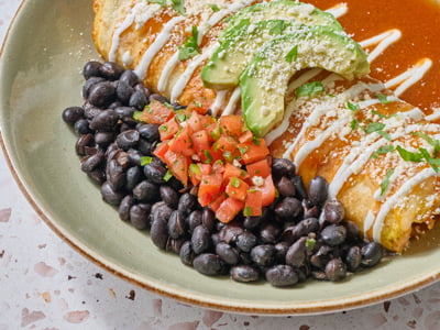 Whipped cage-free eggs with spicy Cajun all-natural chicken breast, chorizo, house-roasted onions, green chiles and Cheddar and Monterey Jack rolled in a flour tortilla. Topped with chili chipotle sauce, lime crema, fresh avocado, Cotija cheese and cilantro. Served with seasoned black beans.