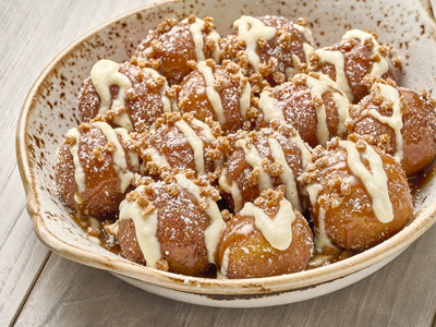 Cake donut holes tossed with pumpkin pie spice sugar, served over warm apple butter and drizzled with crème anglaise and sea salt caramel. Topped with gingerbread cookie crumbles and powdered cinnamon sugar.