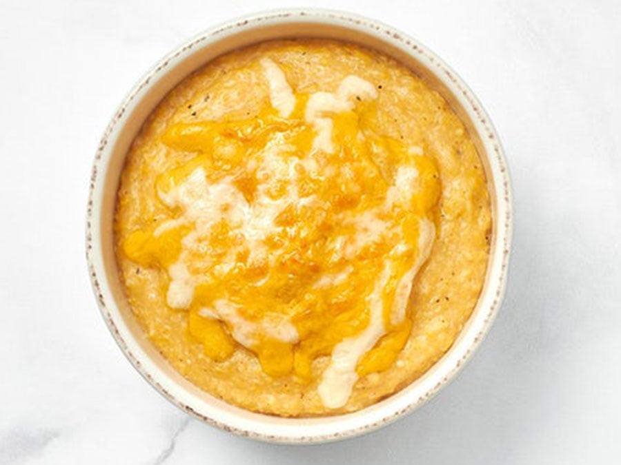 A small bowl of creamy, cheesy grits served hot.